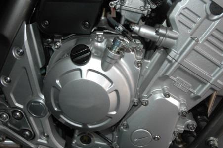 How should the engine oil level of a motorcycle be checked?