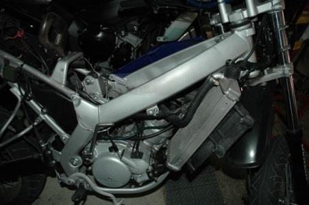 Checking and topping up the coolant of a motorcycle should be done with:
